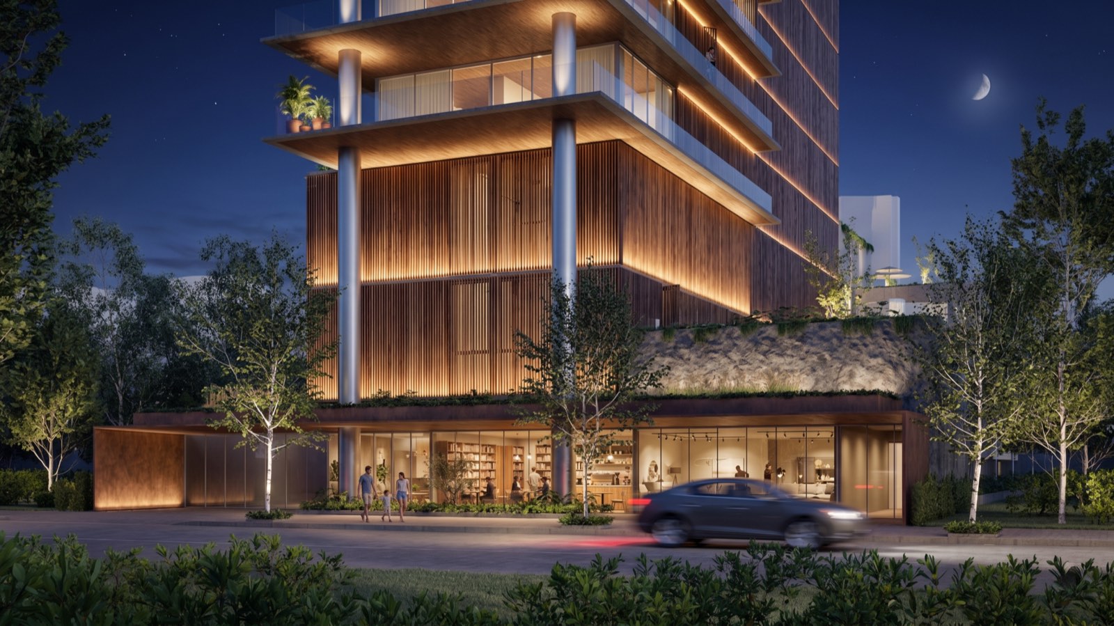Render do Even Pinheiros — a entrada iluminada ao anoitecer, vista da rua